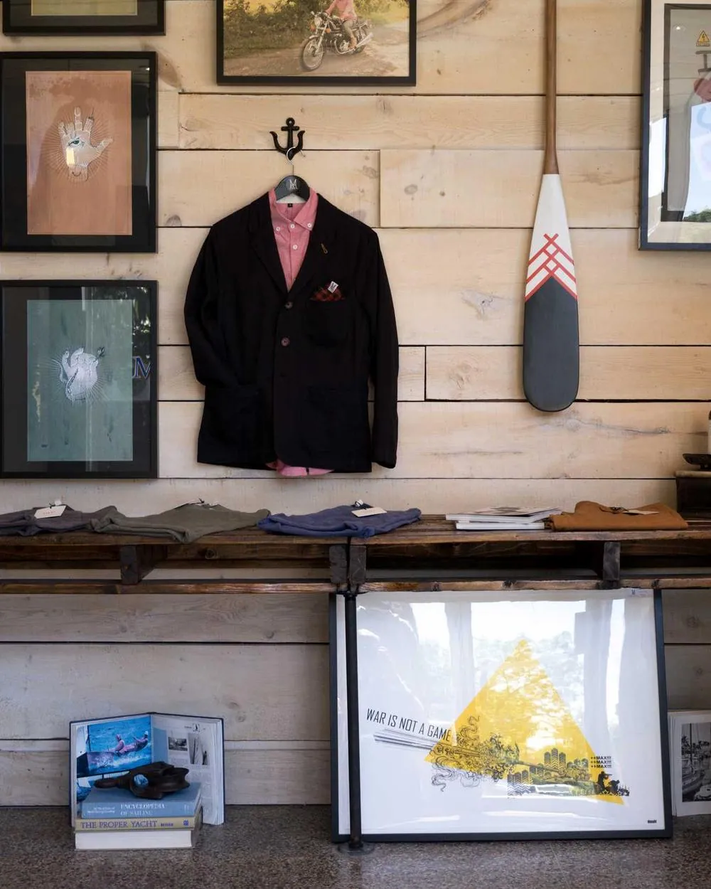 Framed prints and a hanging coat on the studio wall.